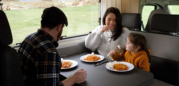 A family enjoying dinner in their campervan 