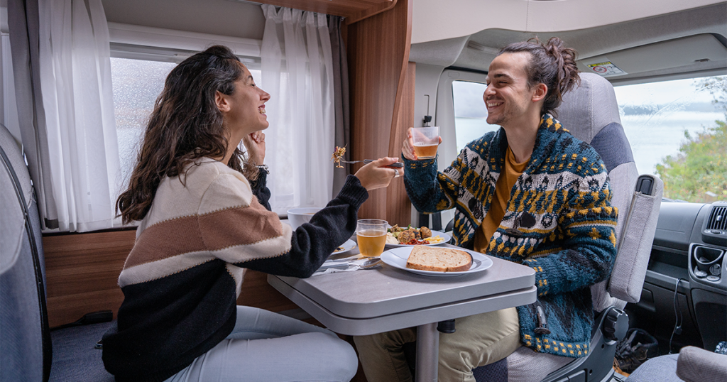 Couple enjoying a romantic meal in their campervan